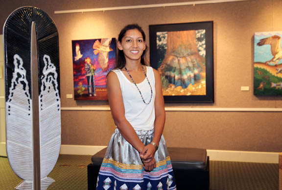 Jessica Osceola stands among artwork created by Native American artists for the ‘Return from Exile: Contemporary Southeastern Indian Art’ exhibition on display at the Collier County Museum in Naples through Jan. 15, 2016. 