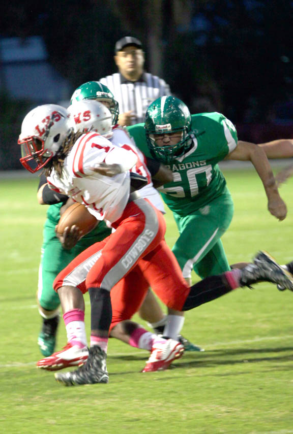 While playing linebacker, Lake Placid’s Wyatt Youngman (60) chases LaBelle running back Maynard Blackmon during the Green Dragons’ senior night game Oct. 16 in Lake Placid. Wyatt also plays center on offense. Lake Placid has played most of the season with only 15 players. 