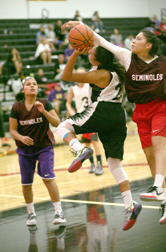 Lady Seminoles’ Ariah Osceola blocks a shot by Lady Ballers’ Courtney Osceola during the Native American Sports Association women’s championship Jan. 16 at the Howard Tiger Recreation Center in Hollywood. 