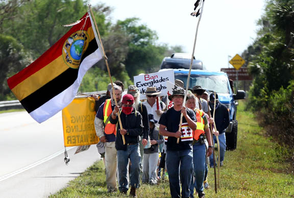 Miccosukee and Seminole Tribe citizens march with environmental activists March 23 during a six-day, 80-mile walk across Tamiami Trail to protest changes that threaten creatures, plants, water and lives in the Everglades.