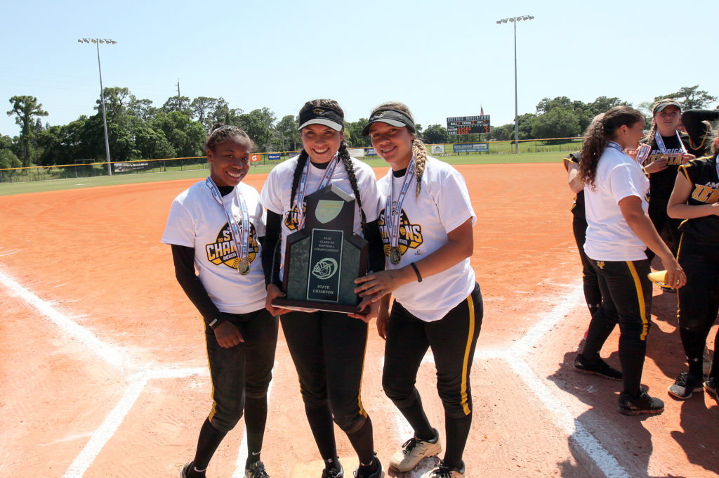 From left, Kiauna Martin, Ahnie Jumper and Budha Jumper hold the state championship after they helped American Heritage cruise past Arnold High School, 12-2, in the 6A title game May 7 at Historic Dodgertown in Vero Beach. 
