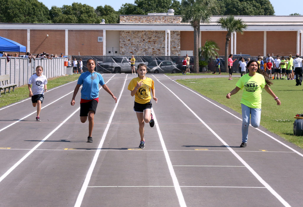 Pemayetv Emahakv’s Lexi Thomas, second from right, crosses the finish line in a sprint at the Okeechobee County track and field meet May 6. 