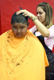ssach Alafaro, 11, prepares to look good for his first day back to school by getting a haircut at the Back-to-School Bash on July 28. 