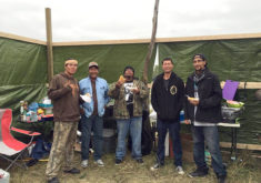 Sam Osceola and Alvin Buster, second and third from left, grab a bite to eat with others at the Sacred Stone Camp in Cannon Ball, North Dakota. (Photo courtesy Martha Tommie)