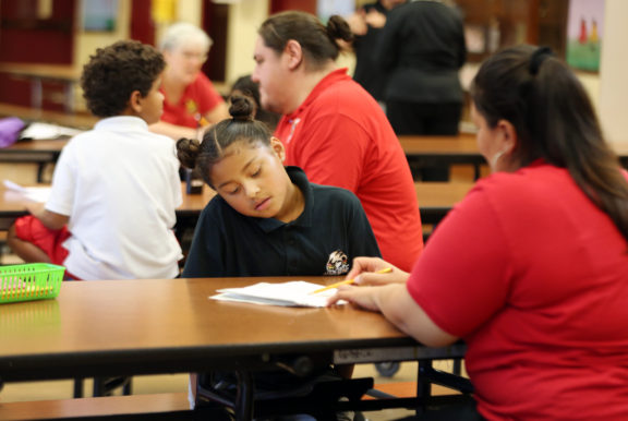 The Ahfachkee cafeteria becomes a study hall during an after school homework help session Sept. 8. Reyna Rios, center, pays attention to the teacher assistant who explains the assignment she must complete. 