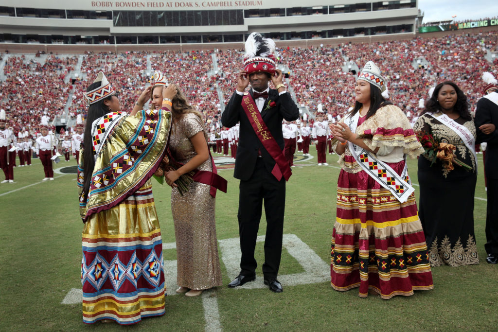 Jr. Miss Florida Seminole Thomlynn Billie places the crown on FSU Homecoming Princess Megan Federico as Homecoming Chief Rashard Johnson adjusts his turban, which was placed on his head by Miss Florida Seminole Kirsten Doney on the 50-yard line of the Bobby Bowden Field at Doak Campbell Stadium during halftime of the FSU-Wake Forest game Oct. 15.