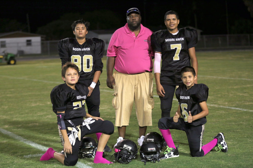 Moore Haven Middle School coach Al Gary joins four of the Seminoles on his team after they defeated LaBelle Middle School on Oct. 13. They are Hyatt Pearce (27), Corey Jumper (80), David King (6) and Jaylen Baker (7). Other Seminoles on the team but not available for the photo are Deagan Osceola and Austin Thomas. (Kevin Johnson photo)