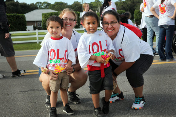 Amber Craig, Andrea Holata and their children take a time out from the Say No to Drugs YOLO Community March in Brighton Oct. 18. (Beverly Bidney photo)