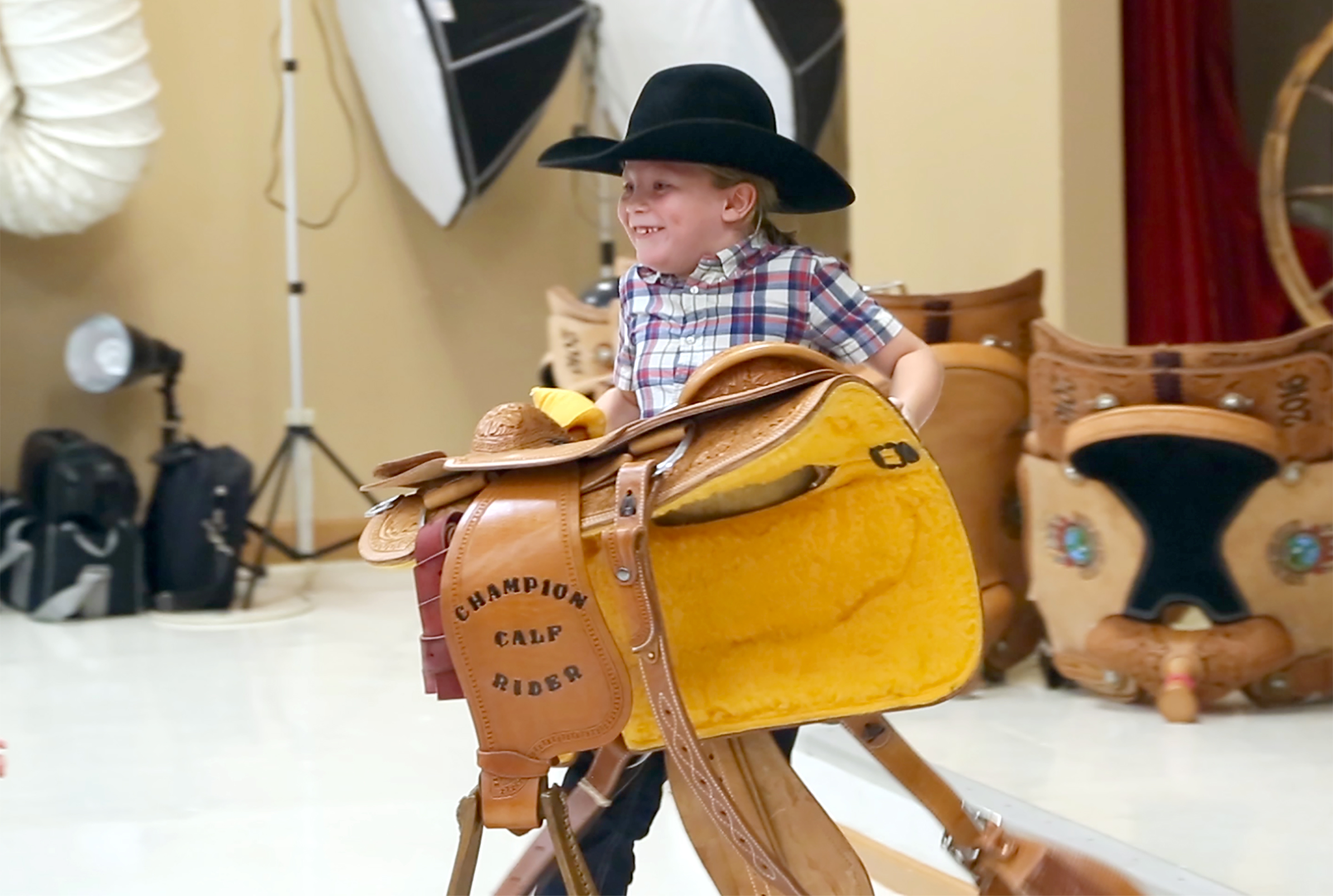 Jace Johns proudly carries the saddle he won as the EIRA youth calf riding champion. (Carlos Fuentes photo)