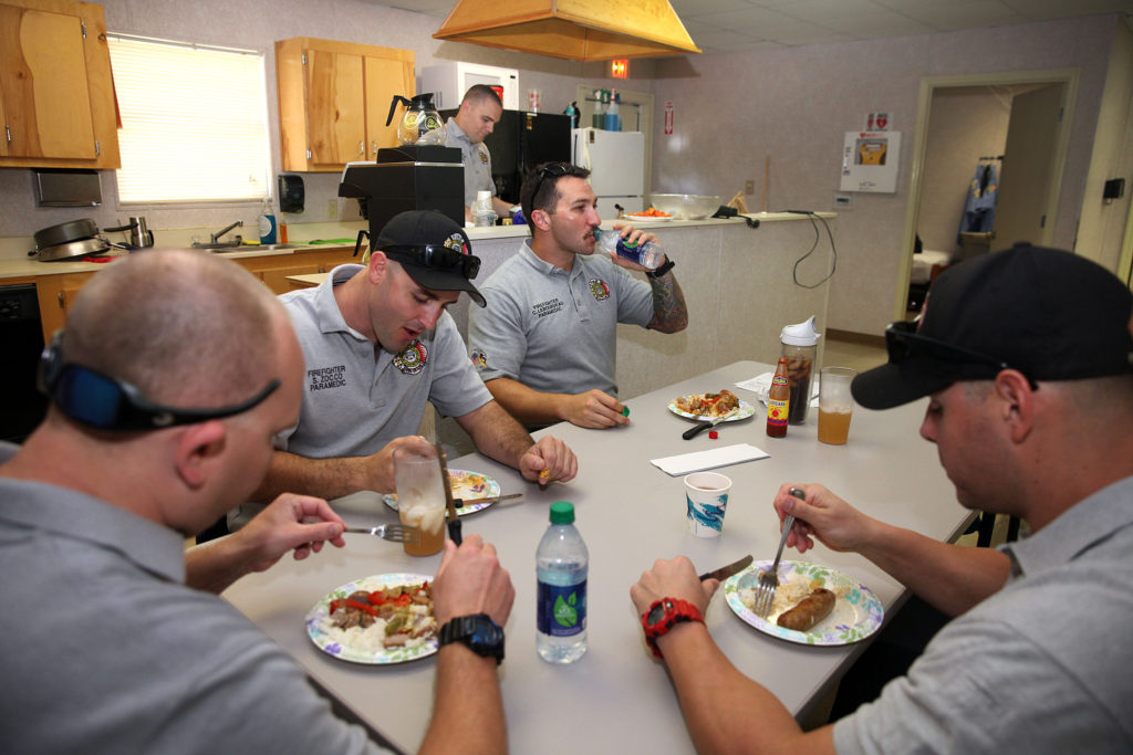 Firefighters Frank Rodriguez, Sal Zocco, Chris Lebourveau, Kris Durthaler and Oscar Castillo enjoy a hearty lunch in the Immokalee Fire Rescue station on Dec. 19. (Beverly Bidney photo)