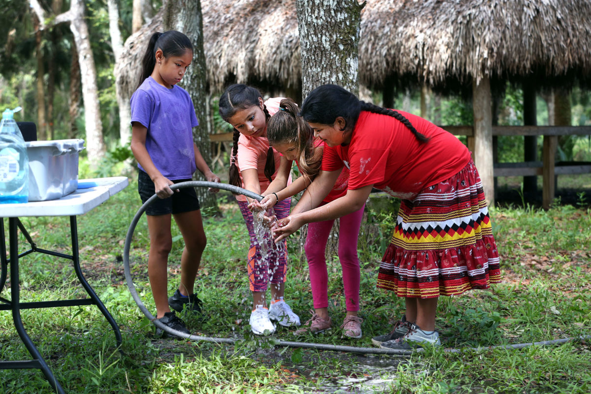 Jazmine Garcia, Arianna Rodriguez, Ayanna Villa and Mary Jane Martinez share the hose as they wash fry bread dough off their hands.  (Beverly Bidney photo)
