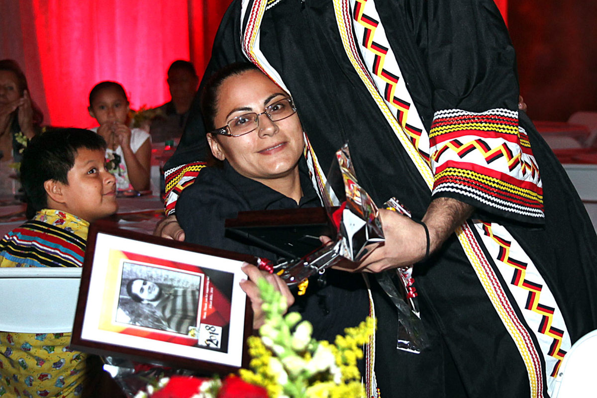 GED graduate Elisah Billie gives his mother Shani Billie a gratitude gift and a hug during the Ahfachkee graduation in Big Cypress. (Beverly Bidney photo)