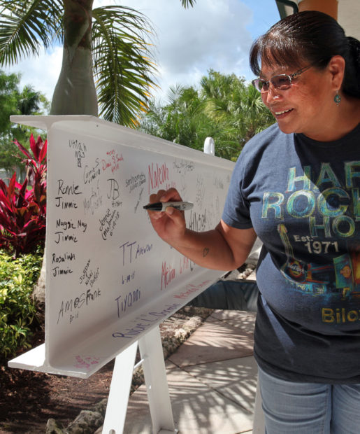 Connie Slavik, of Naples, signs the beam in front of the Immokalee Reservation field office June 25. (Beverly Bidney photo)