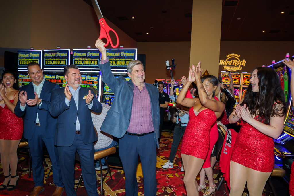 Steve Bonner, president of Seminole Hard Rock Hotel & Casino Tampa, triumphantly raises the oversize scissors he used to cut a red ribbon marking the property’s $65 million in upgrades.