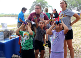 PECS kindergarten students look in the trees for signs of birds or their nests during Brighton’s Earth Day event April 22.
