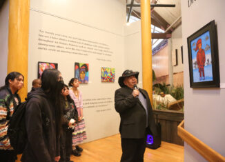 Elgin Jumper talks to students from the Ahfachkee School about his artwork April 4 at the Ah-TahThi-Ki Museum.
