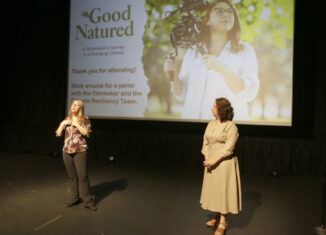 Ashley Stokes, left, and Jill Horwitz speak at the "Good Natured" film screening May 15 at Savor Cinema in Fort Lauderdale. They stand in front of a projector with a photo of Stokes holding a camera on her shoulder. The text to the left of the photo on the projector says "'Good Natured' A Filmmaker's Journey in a Changing Climate. Thank you for attending! Stick around for a panel with the filmmaker and the Climate Resiliency Team."